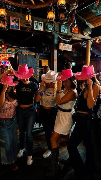 Friends in cowboy hats enjoying a western themed stagette