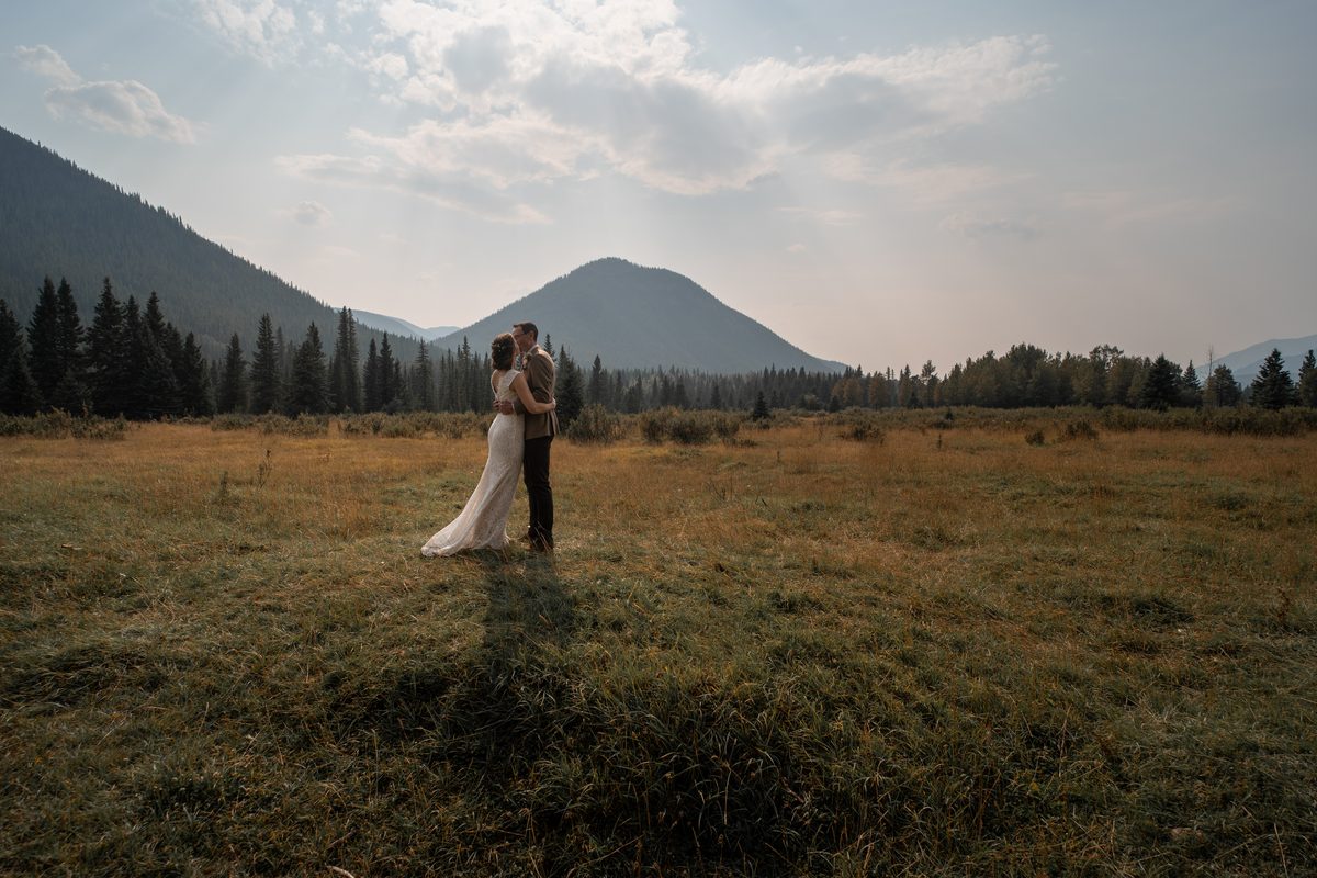 Newly engaged couple walking through a mountain meadow