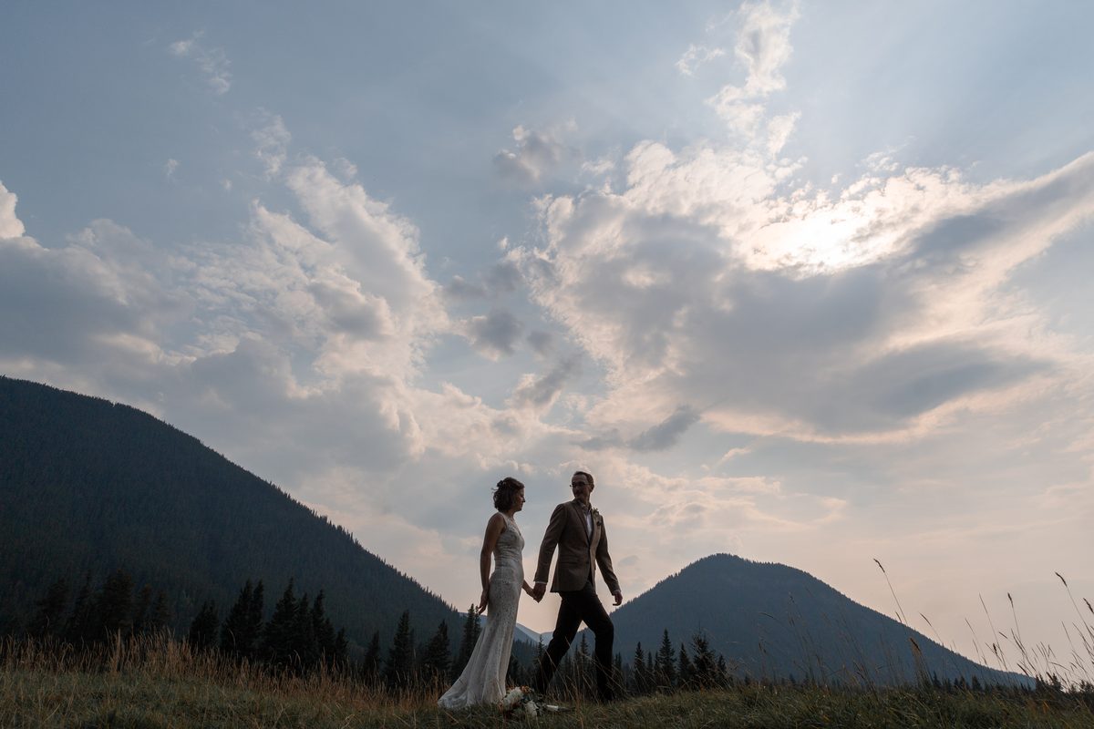 A couple in a mountain meadow at golden hour in the Canadian Rockies